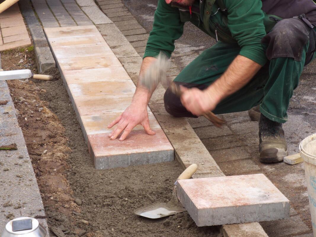 a man hammering concrete blocks